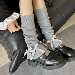 Lolita style grey ribbed leg warmers with white bows paired with black leather loafers