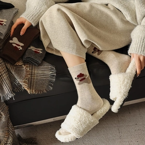 Close-up of thick wool blend socks with cute cartoon puppy design in a cozy home setting