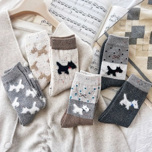Detail of wool socks with cute Scottish Terrier patterns and colorful speckled yarn texture