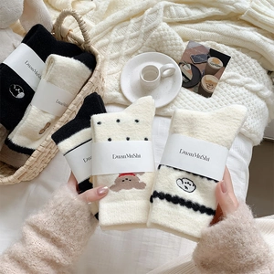 Gros plan de chaussettes thermiques avec broderie de chien et emballage en papier