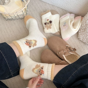 Close-up of thick thermal winter socks featuring cute bear embroidery and fuzzy fleece trim
