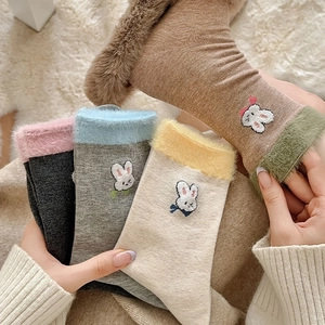 Détail de chaussettes d'hiver avec revers en fausse fourrure et broderie lapin 3D