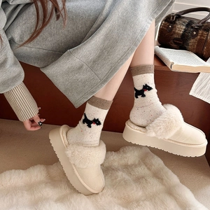 Detail of warm wool socks with dog pattern and platform plush slippers on cozy rug