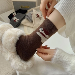 Detail showing wool-blend socks with bear patterns and ribbing in a cozy home setting