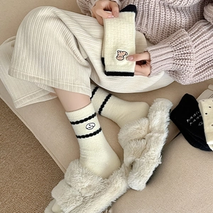 Texture de tricot détaillée des chaussettes d'hiver crème avec broderie et rayures