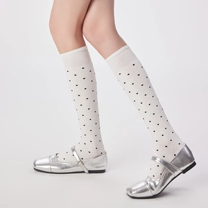 Détail de chaussettes blanches à pois avec bords côtelés et chaussures Mary Jane