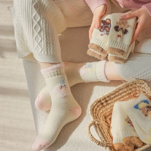 Detail of plush coral fleece socks with cute bear embroidery and thick terry texture