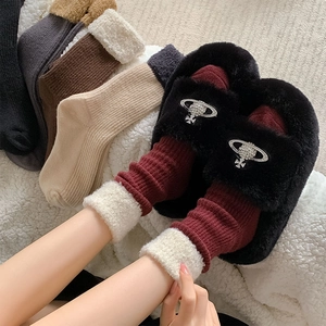 Détail de chaussettes en laine à revers pelucheux et chaussons doux avec boucle Saturne