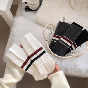 Detail view of thick ribbed knit crew socks with stripe design in cozy home setting