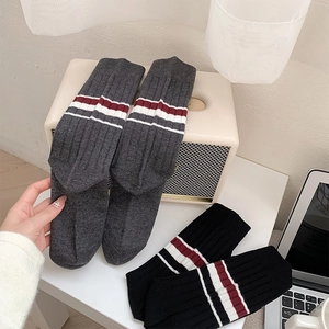 Detailed view of British style ribbed knit socks with red and white varsity stripes