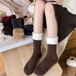 Détail de chaussettes en laine à revers pelucheux en plusieurs couleurs dont rouge foncé