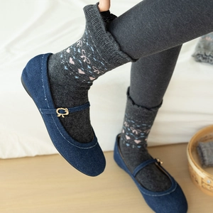 Close-up of grey wool socks with heart patterns and denim Mary Jane shoes