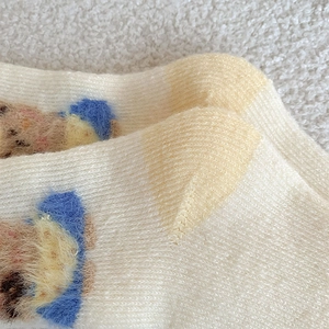 Detailed macro view of the reinforced heel on thick knitted winter socks with cartoon bear