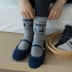 Close-up of grey wool socks with elk pattern, featuring wavy edges and warm knit texture