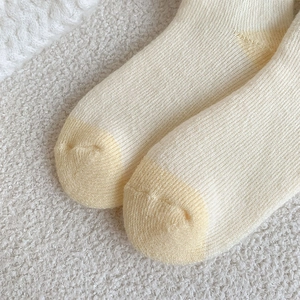 Close-up of cream and yellow ribbed knit socks showing thick texture and toe stitching