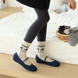 Detail of Nordic wool socks with elk patterns and Mary Jane shoes in a cozy setting