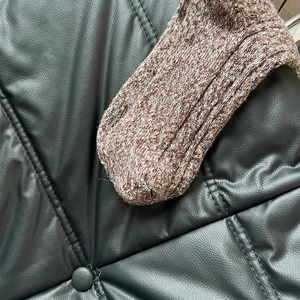 Gros plan d'un tricot épais en laine marron mélangée avec une texture bouclée et chaude