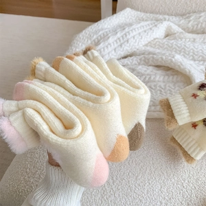Close-up of thick knitted winter crew socks with plush cuffs in various colors