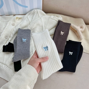 Détail de chaussettes en maille côtelée avec broderie nœud élégante et texture douce