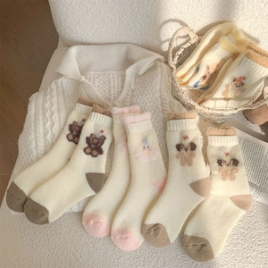 Close-up of cute teddy bear embroidery on warm plush thermal socks for winter
