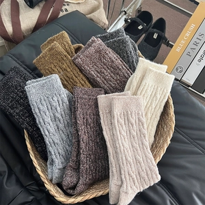 Détail de chaussettes épaisses en laine aux motifs torsadés et tons terre d'automne