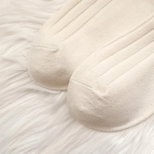 Close-up of cream white ribbed knit sock toe showing thick warm texture and stitching