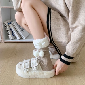 Chic cream fur slides with double buckles and matching pom-pom calf socks on wood floor