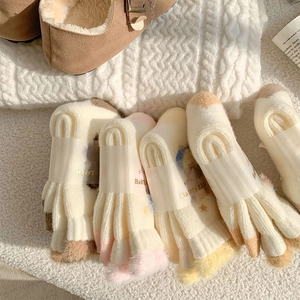 Close-up of soft plush thermal socks with multi-color splicing on a white knit blanket