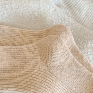 Gros plan de chaussettes en laine beige montrant la texture sur fond polaire