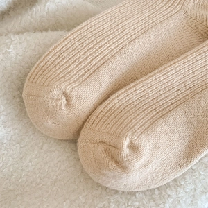 Gros plan sur la maille côtelée épaisse de chaussettes en laine beige pour l'hiver