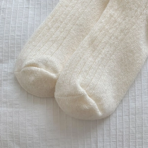 Detail of off-white ribbed knit socks with thick fuzzy texture and reinforced stitching