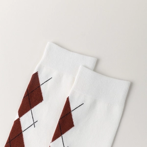 Close-up of vintage argyle pattern and ribbed elastic cuff on white knee-high socks