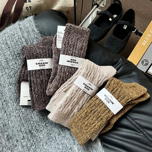 Détail de quatre paires de chaussettes épaisses en laine torsadée aux tons terre
