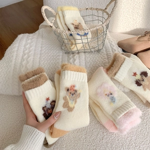 Detail of plush thermal winter socks featuring cute bear embroidery and fuzzy trim