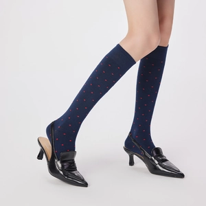 Chaussettes hautes marine à pois rouges portées avec des escarpins noirs à bouts pointus