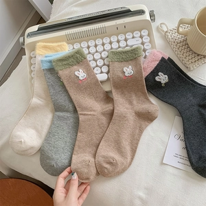 Détail de broderie lapin mignon et poignets en peluche colorés sur chaussettes en coton