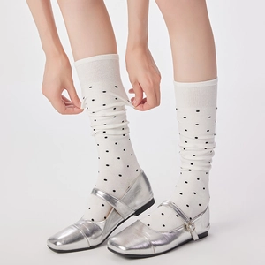 Chaussettes à pois blancs et noirs portées avec des chaussures Mary Jane argentées