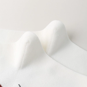Macro shot of fine knitted texture on white knee-high socks with smooth warm finish