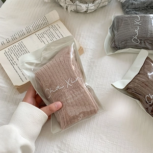 Detail view of winter knitted socks in neutral tones with minimalist packaging