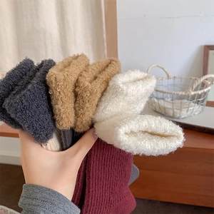 Gros plan de chaussettes en laine épaisses avec revers en peluche en plusieurs couleurs