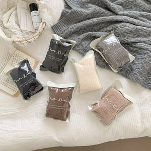 Detail of 5-pack thick ribbed knit mid-calf socks in various colors on white bedding