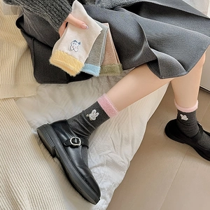 Détail de la broderie lapin et du bord en fausse fourrure sur chaussettes mi-mollet