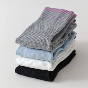 Dettaglio di quattro paia di calze da yoga a costine nei colori grigio, blu, bianco e nero