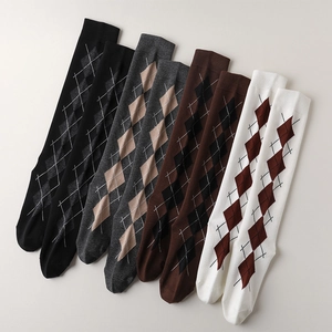 Close-up of four argyle socks in black, grey, brown, and beige with ribbed cuffs