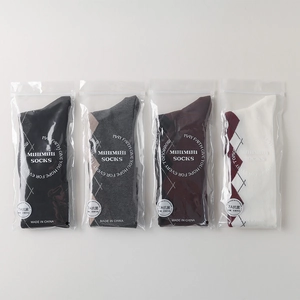 Detail of four pairs of argyle knee-high socks in individual zip-lock packaging