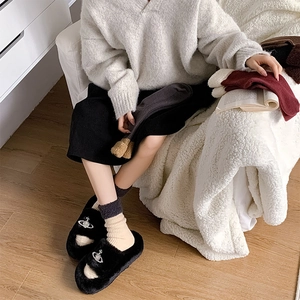 Vue détaillée de chaussettes en laine épaisses avec revers en peluche et pantoufles noires