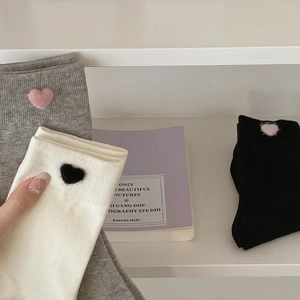 Detail of grey crew socks featuring soft heart-shaped fuzzy patches and ribbed knit texture