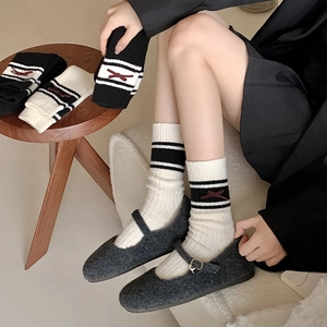 Chic wool socks with red bows and stripes shown in a cozy lifestyle setting
