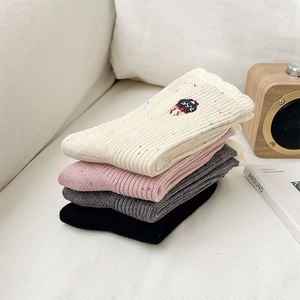 Detailaufnahme der süßen Katzenstickerei auf bunten, gesprenkelten Kaschmir-Socken