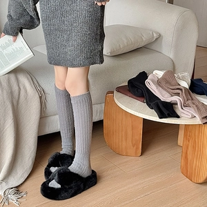 Detailed knit texture of calf-high ribbed socks in multiple colors with grey variant